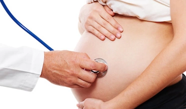 doctor attentively listening pregnant woman's belly